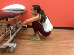 Lindsay is completing a full squat and breathing, stretching out her back muscles and inhibiting her extensor tone